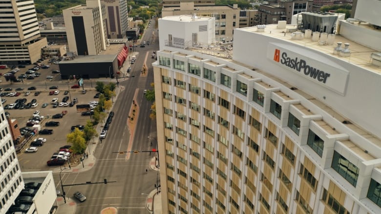 An aerial shot shows a tall building with a sign reading 