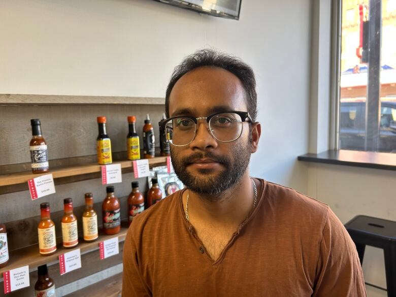 A bald man in a brown shirt.