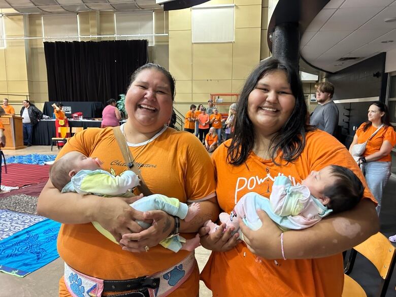 Brandy Googoo, left, and Dezaray Googoo hold two-month-old twins Char and Kensley during the blanket exercise at UPEI on Saturday.