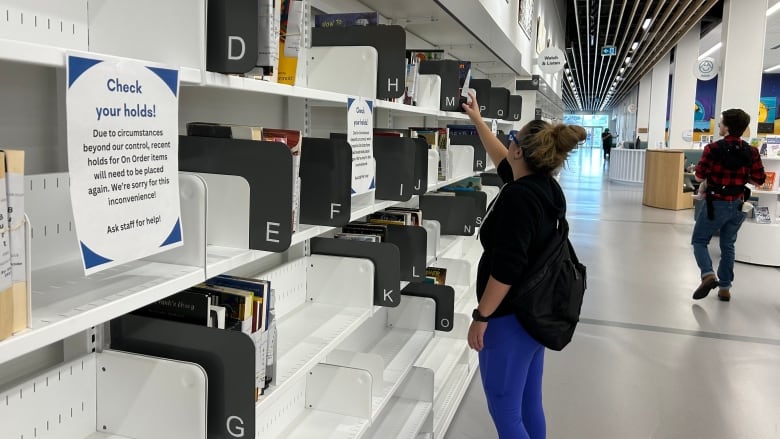 Woman checks library shelves