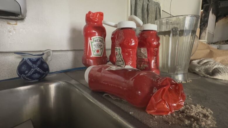 Several ketchup bottles are melted and mishapen. 