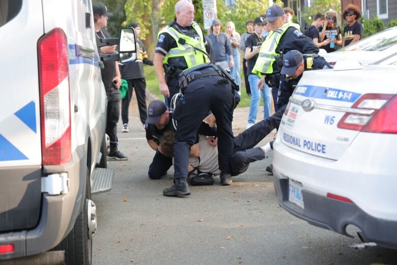 Police wrestle a young man to the street 