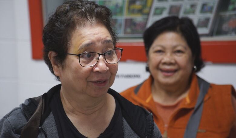 Two women stand side-by-side, smiling after voting.