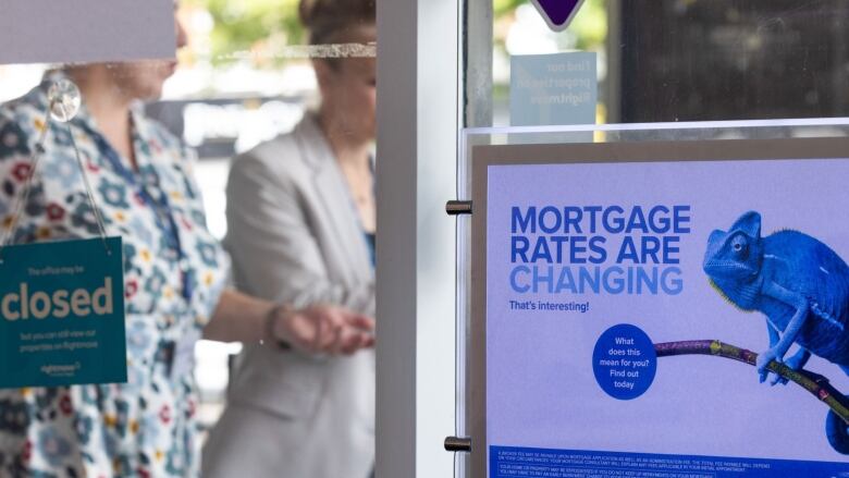 A sign on the window of a mortgage office is shown.