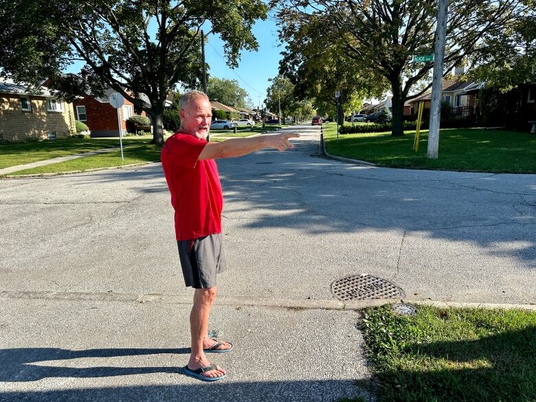 A man points down residential streets.