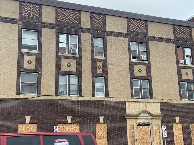 A wide outdoor shot of the boarded up apartment building