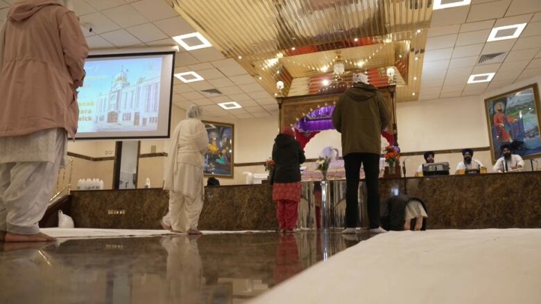 People mill about the lobby of a Sikh temple.