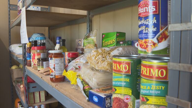 Some canned foods and other goods atop a pantry.