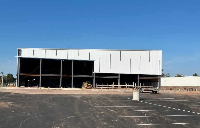 A partially constructed building can be seen with a parking lot in the foreground.