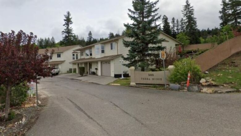 The entrance to a housing complex, and the building itself, is shown.