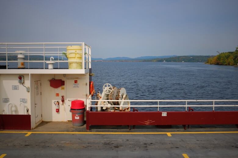 A red ferry deck with fall colours just starting to come into the trees in the background