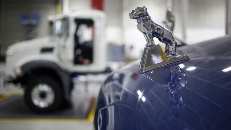 A bulldog hood ornament is shown on a Mack Truck on the assembly line.