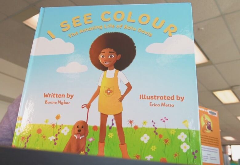 A hardcover book with a little girl and a dog on the front. The title above the girl's head says 