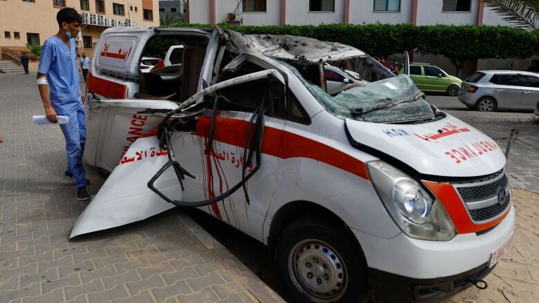 A battered ambulance van with streaks of blood from the sides. 