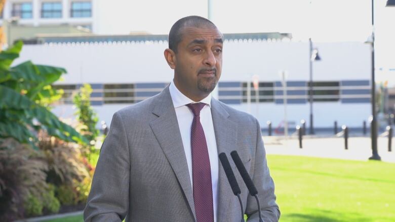 A man in suit speaking into a mic.