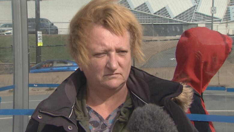 A woman with blonde hair speaks to the camera.