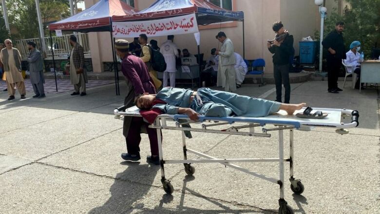 A man pulls a stretcher with an injured man.