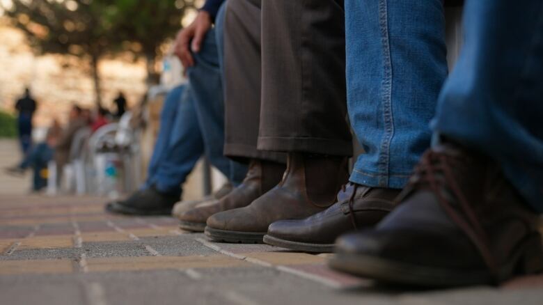 A row of men wearing boots.