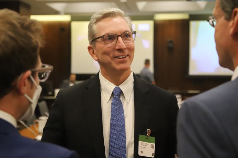 A man wearing a suit smiles.