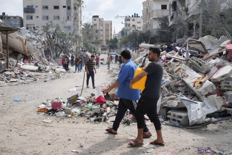 A Palestinian carries a water canister 