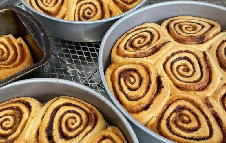 Swirls of cinnamon buns sit in silver pans used by the culinary arts students.