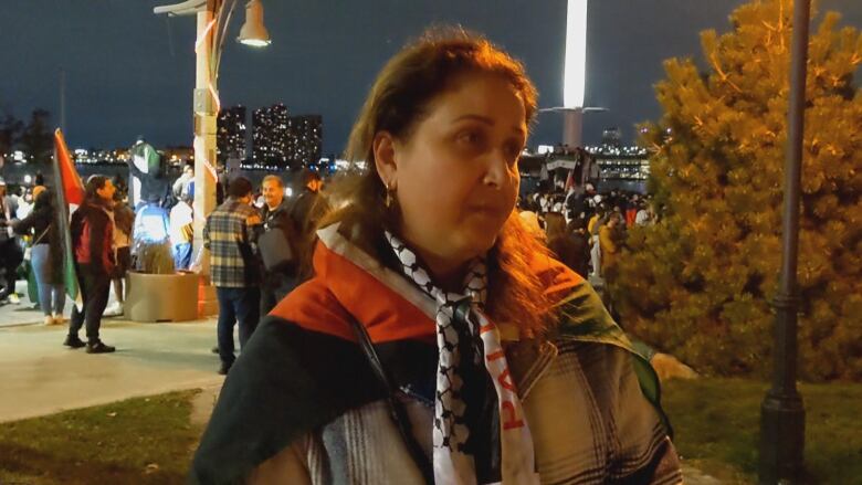 A woman with a flag tied around her shoulders