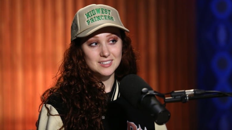 Chappell Roan wearing headphones, sitting in front of a studio microphone.