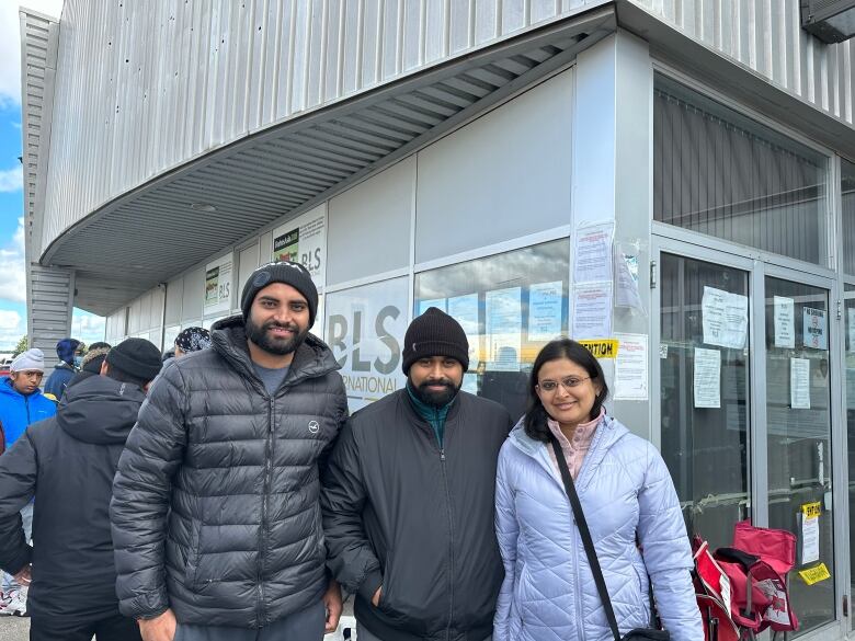 Three friends waiting outside to get their OCI cards. 