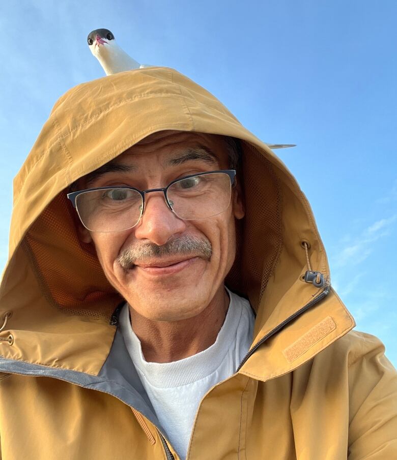 Picture of a man in a yellow raincoat.