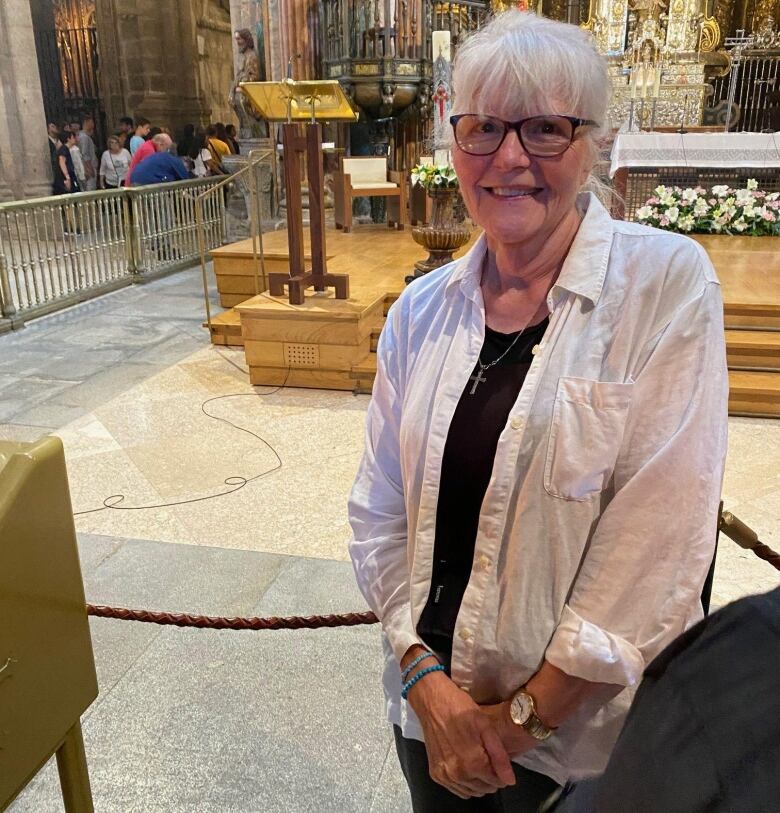 A woman stands in a cathedral.