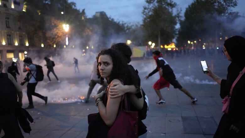 Protestors walk on the Republique square as riot police use tear gas during a rally in solidarity with the Palestinian people in Gaza, in Paris, Thursday, Oct.12, 2023.