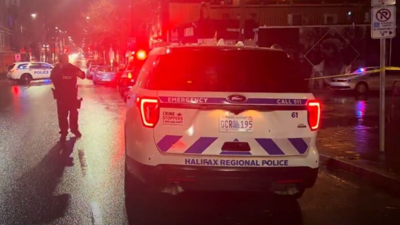 Multiple police vehicles and a police officer are shown at a crime scene on Gottingen Street in Halifax in the early hours of Oct. 22, 2023.