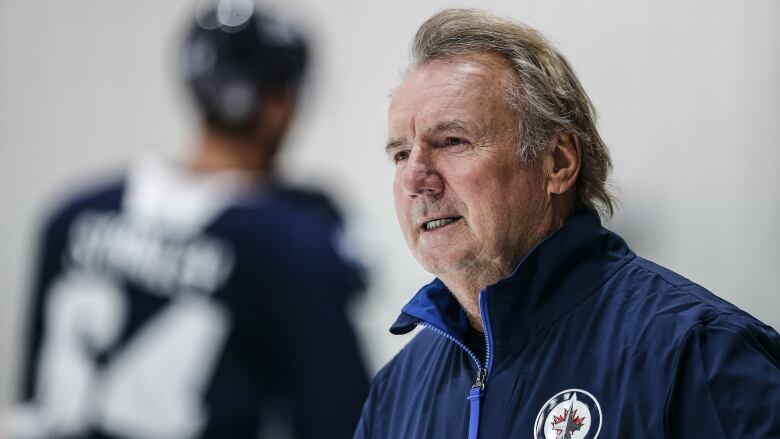 A portrait of a man wearing a blue jacket.