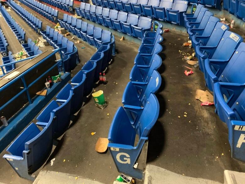 Wide photo of garbage seen near the seats of a hockey arena. 