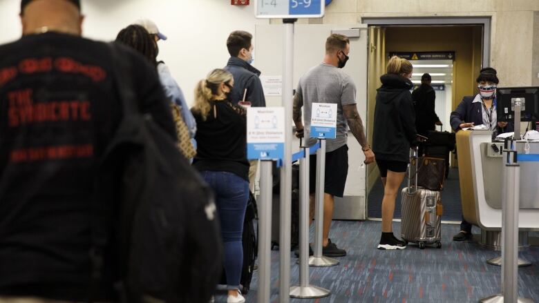 Passengers line up to board a plane.