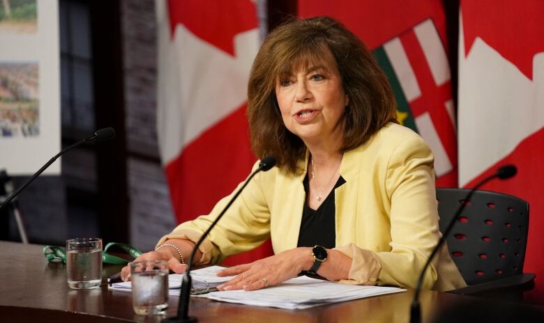 Bonnie Lysyk sitting at a desk in the media studio at Queen's Park. 