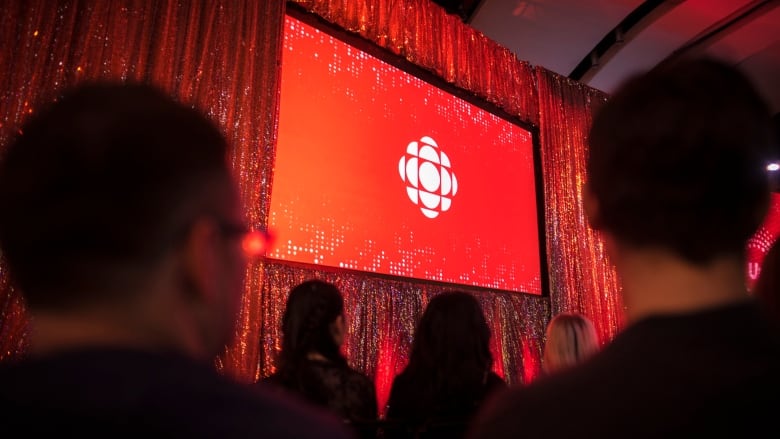 The CBC logo is projected onto a screen.