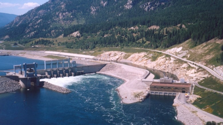 Bird's eye view of a dam in a reservoir and surrounding hills.