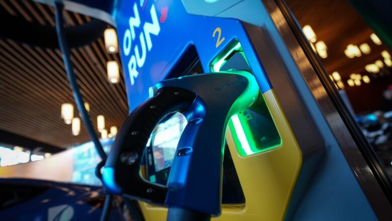 An electric vehicle charging station is displayed in an exhibition showroom. 