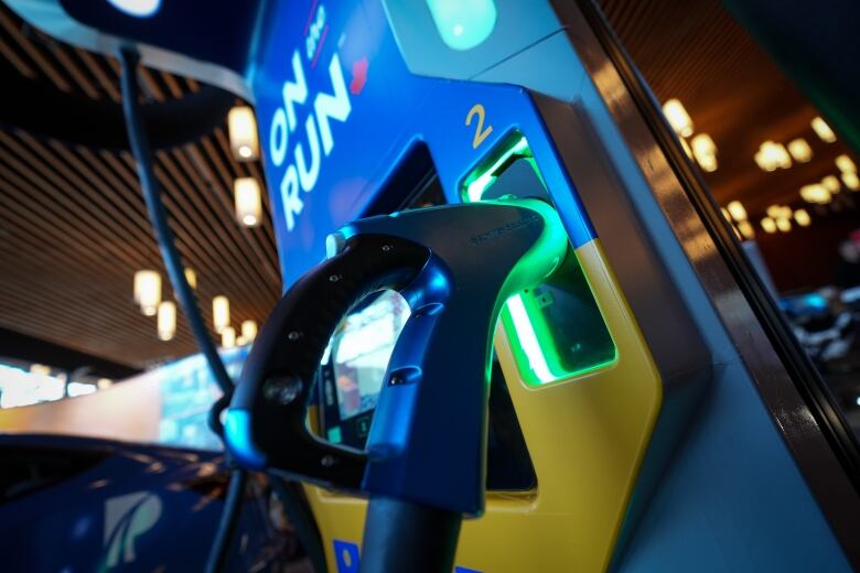 An electric vehicle charging station is displayed in an exhibition showroom. 