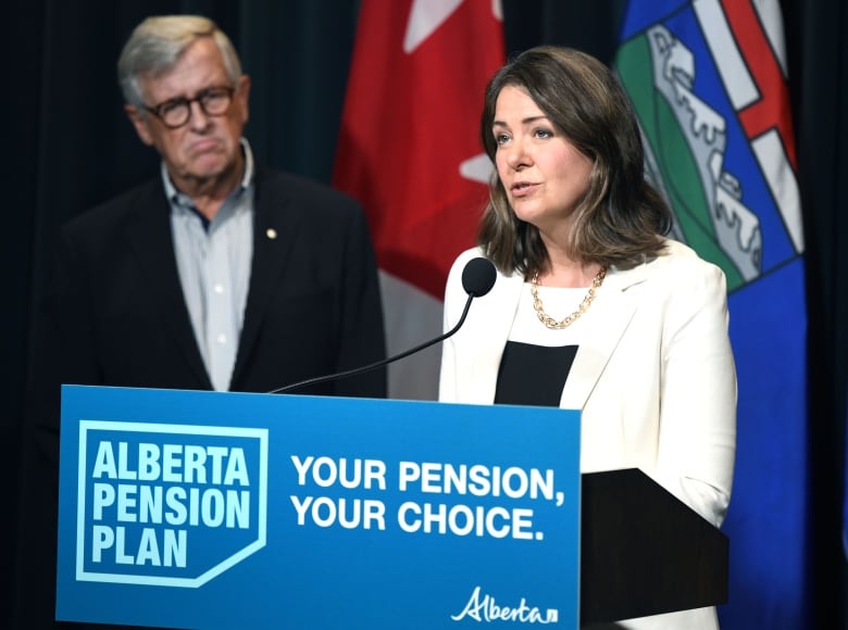 Jim Dinning watches as Premier Danielle Smith speaks at the Sept. 21 release of a report about an Alberta pension plan. Dinning, a former provincial finance minister, heads an engagement panel that will hold a series of telephone town halls across Alberta to gauge support for the proposed plan.