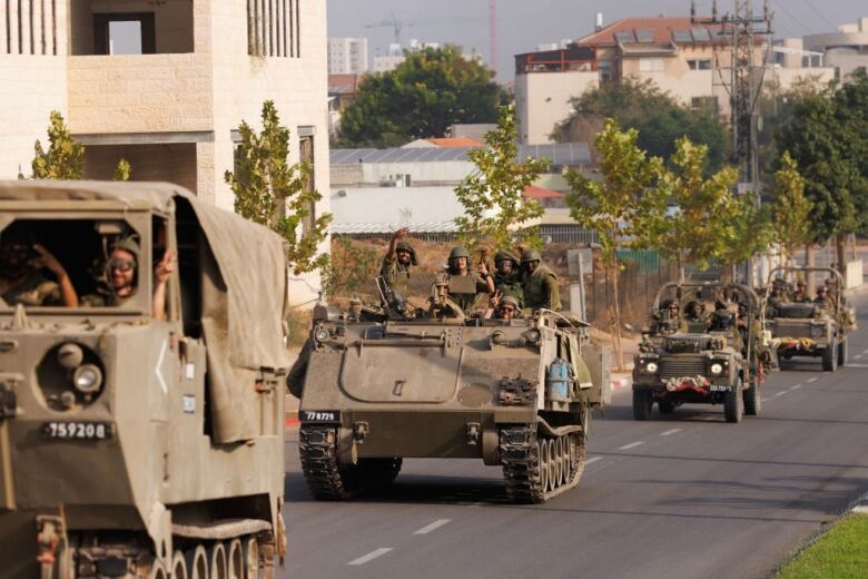 Tanks are driven along a street.