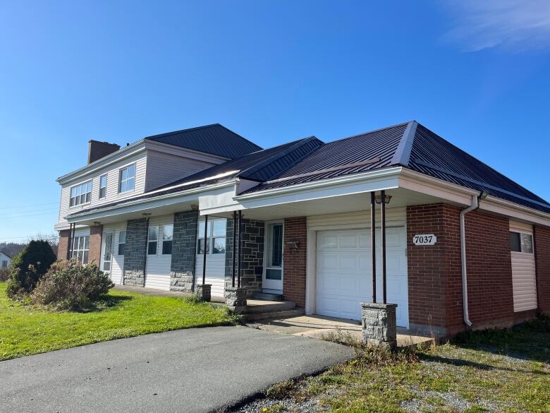 A two level home is seen with a white garage door.