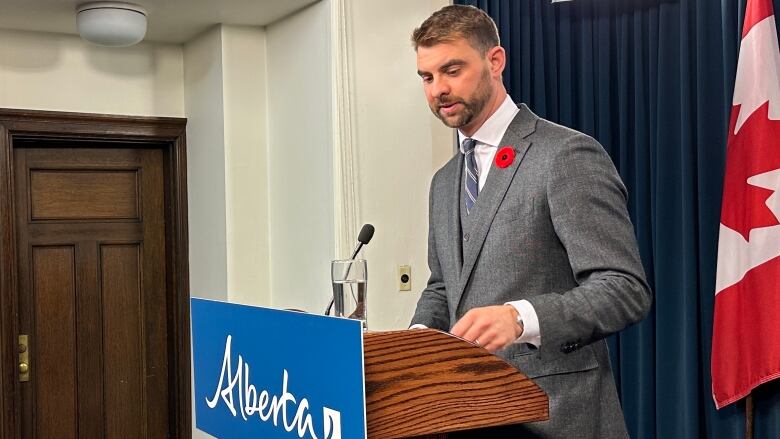 Mental Health and Addictions Minister Dan Williams standing at a podium during a news conference in Edmonton. 