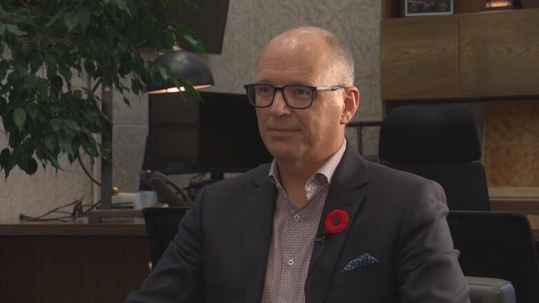 A man in a suit is sitting in an office.