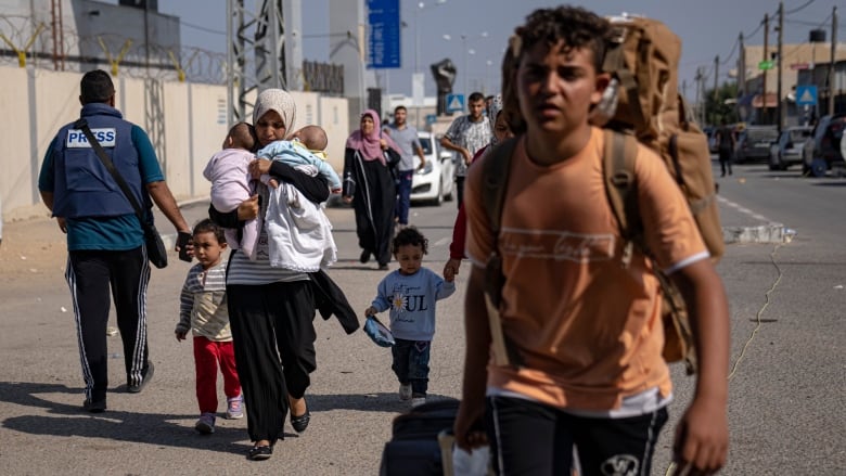 Weary-looking Palestinians arrive at Rafah carrying knapsacks, suitcases and children.