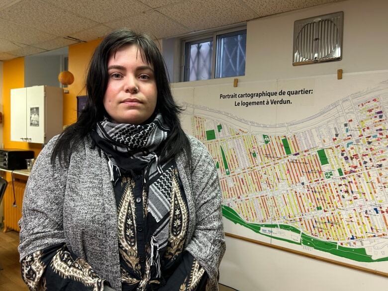 A woman standing in front of a map of Verdun. 