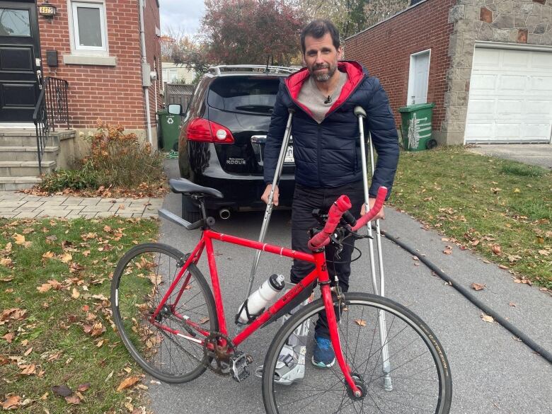 Man in ankle cast standing with bicycle