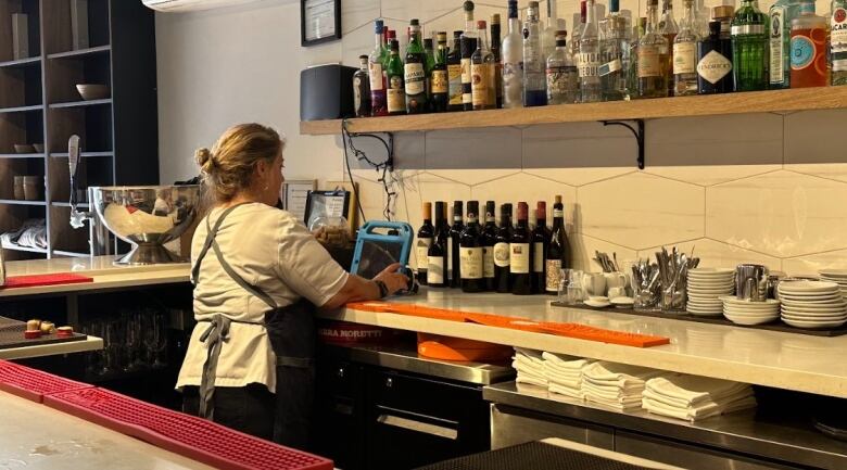 Restaurant owner Alida Solomon works the till at her restaurant Tutti Matti in Toronto.