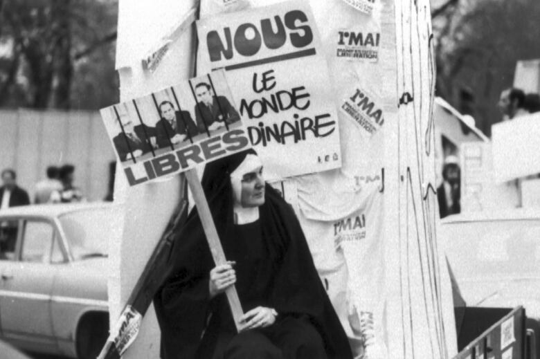 A nun holds up a sign.